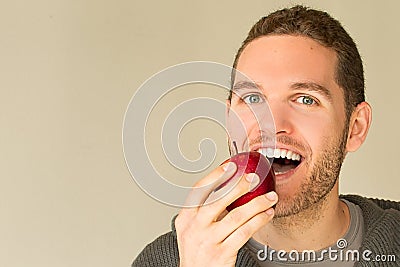 Man with funny face looking at an apple