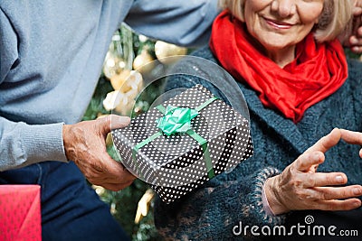 Man Giving Christmas Present To Woman At Store