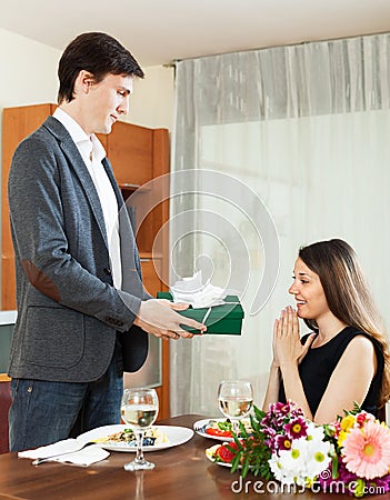 Man giving present to woman during romantic dinner