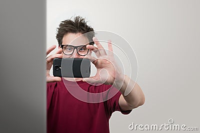 Man in glasses photographed by smartphone