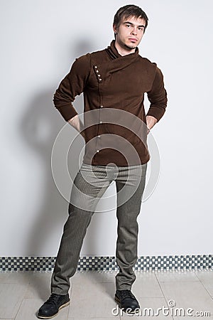 The man in gray trousers and fashionable brown sweater