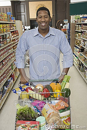 Man With Grocery Shopping In Supermarket Aisle