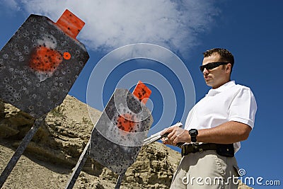 Man With Hand Gun Near Targets At Firing Range