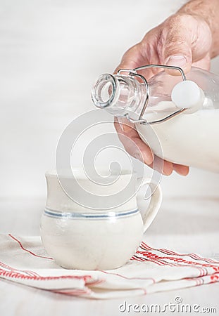 Man hand pouring milk from bottle