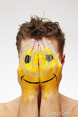 Man hiding his face under smile mask