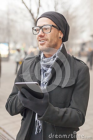 Man holdin ipad tablet computer on street