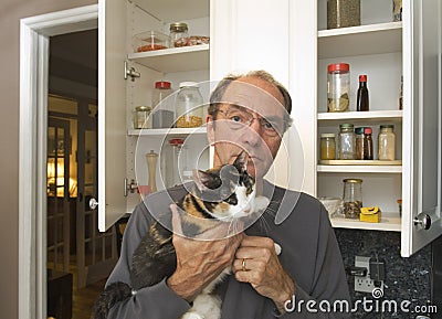 Man holding cat in kitchen