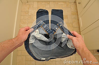 Man holding pants before putting them on