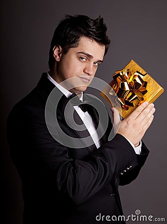 A man holding present box in formal black tux