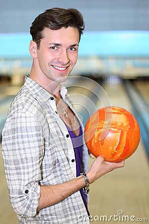 Man holds ball in bowling club