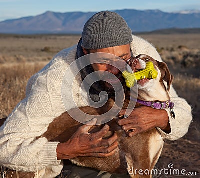 Man hugging and playing with his dog