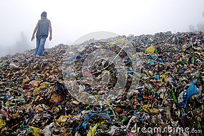 Man Inspecting an Mountain of Trash