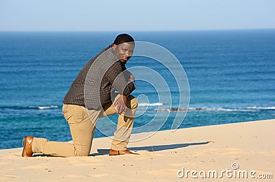 Man kneeling on beach