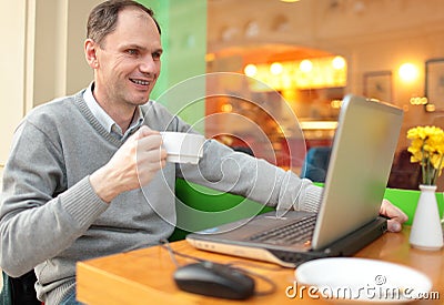 Man with laptop in a cafe