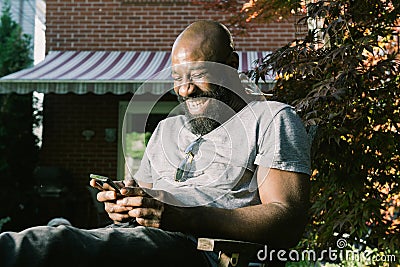 Man Laughs Reading Text Message in Garden