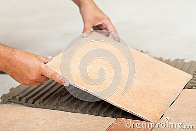 Man lays ceramic floor tiles - closeup