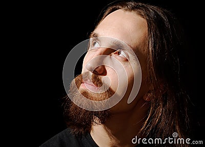Man with long hair and beard looking up and left