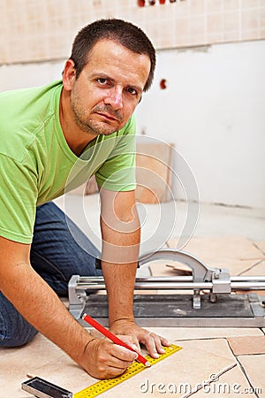 Man marking and cutting ceramic floor tiles