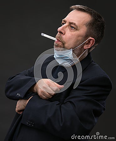 Man in medical mask with a thermometer