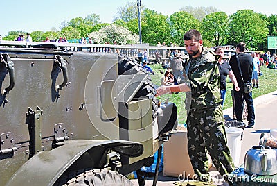 A man in military uniform prepares food.