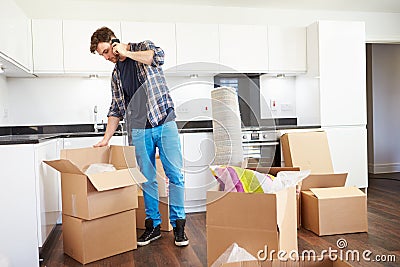 Man Moving Into New Home Talking On Mobile Phone