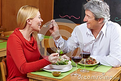 Man offering woman bite from fork