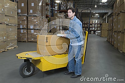 Man Operating Trolley In Warehouse