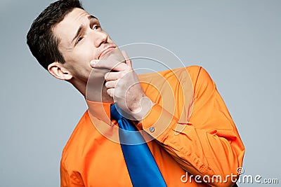 Man in orange shirt thinking about problem.