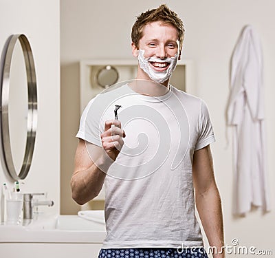 Man in pajamas in bathroom shaving