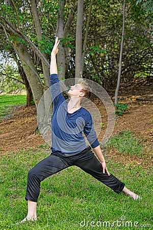 Man Performs Reverse Warrior Yoga Pose in Park