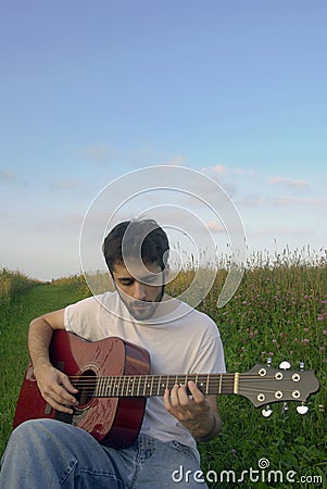 Man playing guitar in field