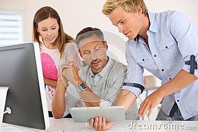 Man presenting results at colleagues on tablet