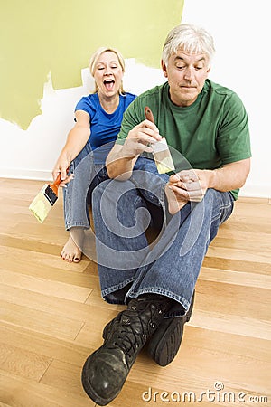 Man pretending to paint woman s toenails.