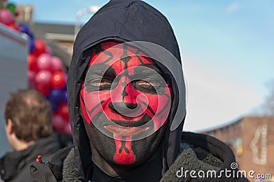 Man with a red and black painted face.