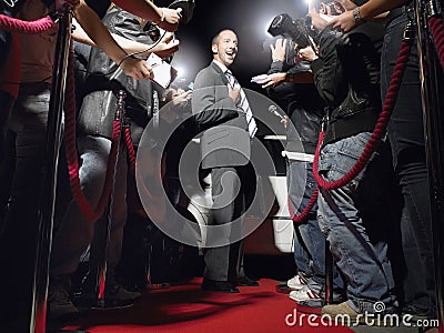 Man On Red Carpet Posing In Front Of Paparazzi