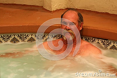 Man relaxes in jacuzzi spa