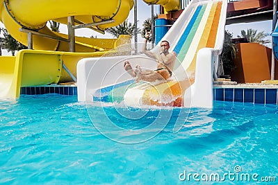 A man rolls down a hill in a aquapark