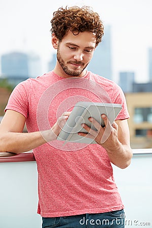 Man On Roof Terrace Using Digital Tablet