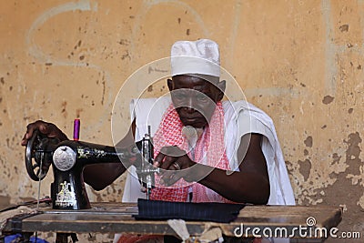 Man sewing on a machine, on market Djenne, Mali