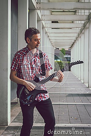 Man in short sleeve shirt playing electric guitar