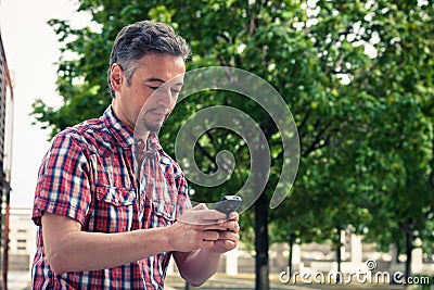 Man in short sleeve shirt texting on phone