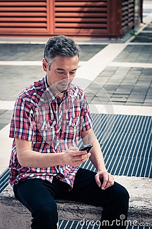 Man in short sleeve shirt texting on phone