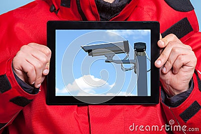 Man showing security system camera on tablet