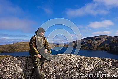 Man sits on a mountain top. Ridge Musta Tunturi.