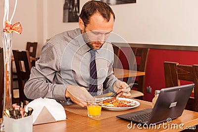Man sitting alone in restaurant with laptop