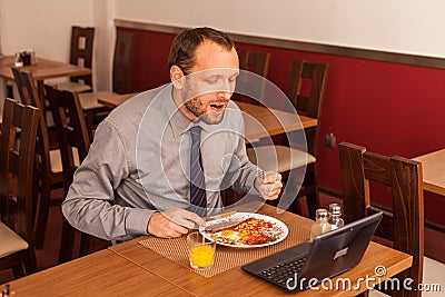 Man sitting alone in restaurant with laptop