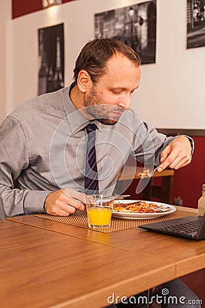 Man sitting alone in restaurant with laptop