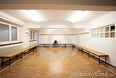 Man sitting in empty locker room