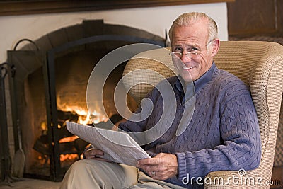 Man sitting in living room by fireplace