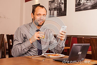 Man sitting in restaurant with laptop,and phone